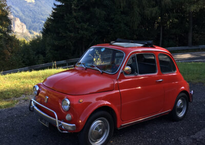 Red classic Fiat 500 in the shade
