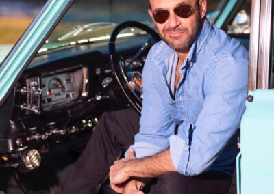 Man smiling in open driver seat of Jeep Kaiser