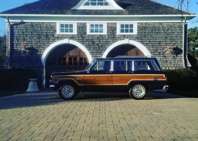 Vintage Jeep parked in front of large house