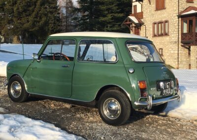 Vintage green Austin Mini-matic parked in front of a house