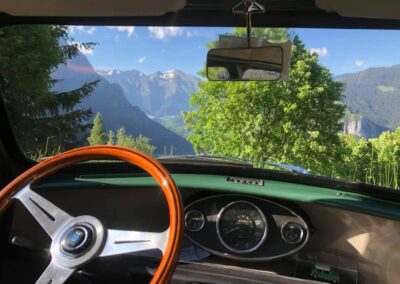 View from inside a classic Austin Mini-matic, with wooden steering wheel and dashboard