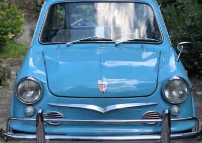 Front view of a baby blue NSU Prinz car