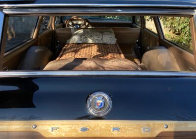 Closeup of a bed set up inside a vintage Ford station wagon