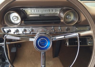 Closeup of dashboard controls and chrome steering wheel on vintage Ford Galaxie 500 station wagon