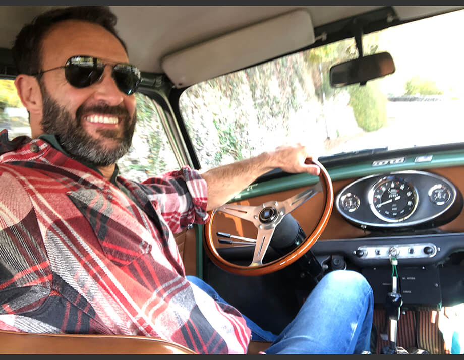 Man smiling from inside a Jeep Kaiser Wagoneer