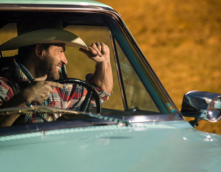 Marco wearing a cowboy hat in a Jeep Kaiser Wagoneer